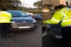 Watch - Man attempts to drive away car with police on bonnet