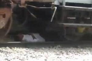 Watch - Man has close call as he lies down on tracks while train passes over him